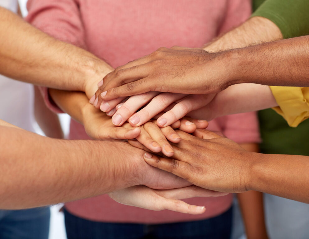 friendship, international, teamwork and people concept - close up of hands on top of each other